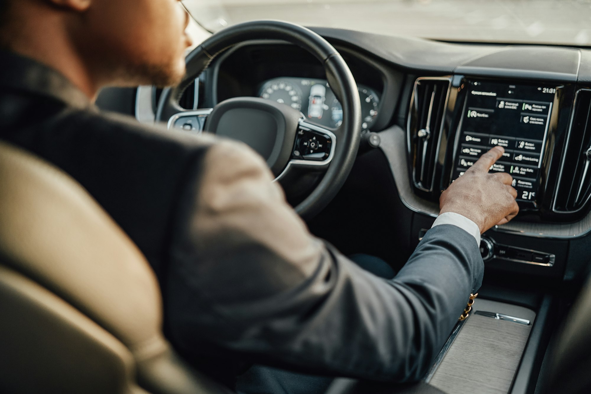 Black businessman inside car using car panel